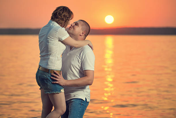 istock Young romantic couple enjoying the sunset 518818419