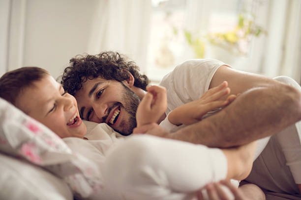 istock Happy father and son playing in bed. 518818676