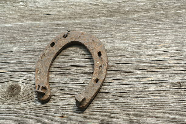Rusty horseshoes on a wooden background.