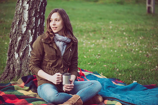 istock Brunette woman resting under a tree outdoor. 518828056