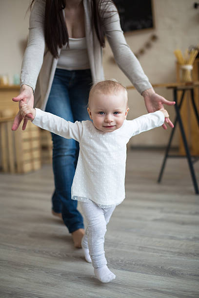istock Mom and daughter having fun playing together, Toddler first step 518828786