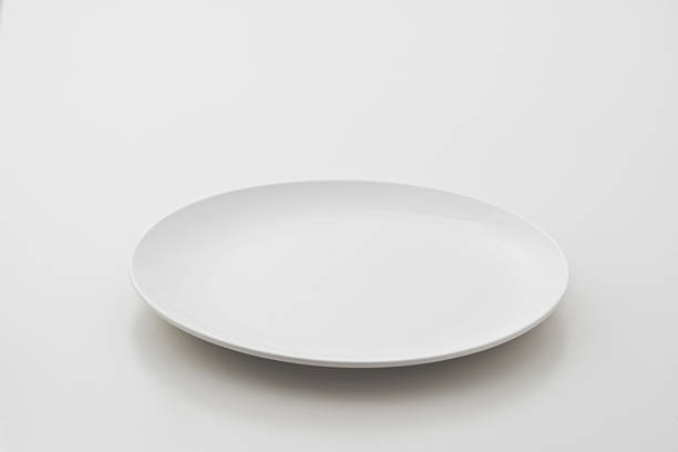 Circular porcelain plate on white background stock photo