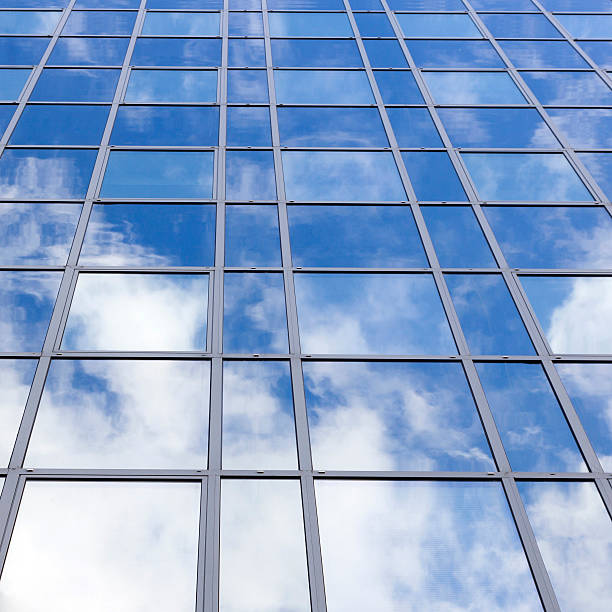 istock glass office facade reflects clouds and blue sky 518832886