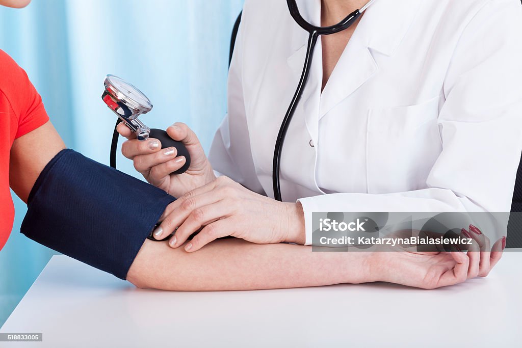 Doctor doing professional pressure examine Doctor doing professional pressure examine her young patient Adult Stock Photo