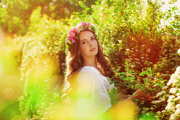 Young beautiful girl with long hair in floral wreath stock photo