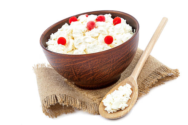 istock Cottage cheese in a bowl and a wooden spoon 518833434
