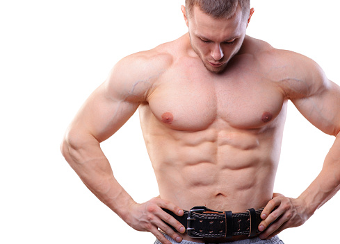 Muscular man with lifting belt posing over white isolated background. 