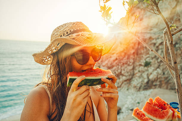 come y disfruta de sandía - women summer hat beach fotografías e imágenes de stock