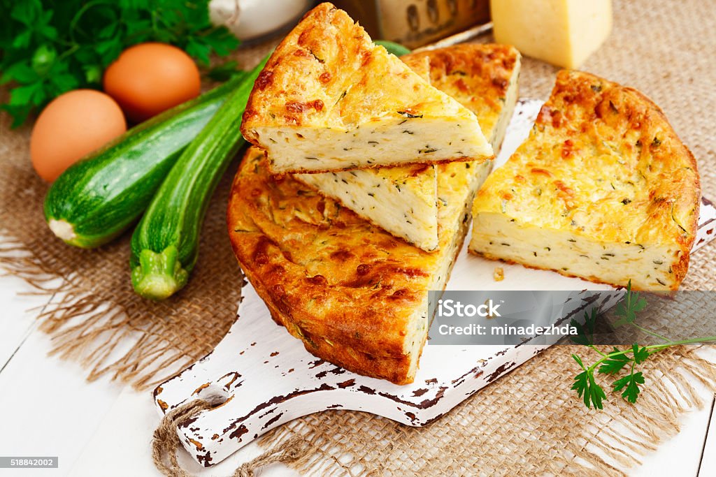 Zucchini pie with cheese and herbs Pie with zucchini, cheese and herbs on the table Baked Stock Photo