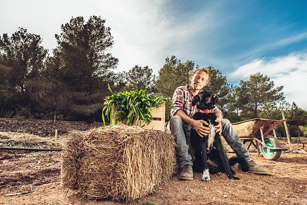 istock Young Farmer and his dog on the field 518842170