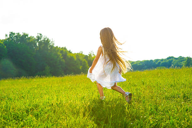istock Little girl running on green grass. 518842864