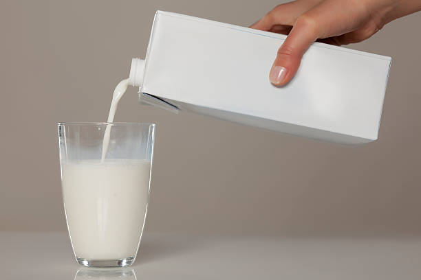 pouring milk pouring milk from the carton into a glass milk carton stock pictures, royalty-free photos & images