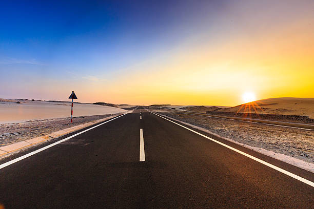istock Road through desert landscape under sunset sky 518843428