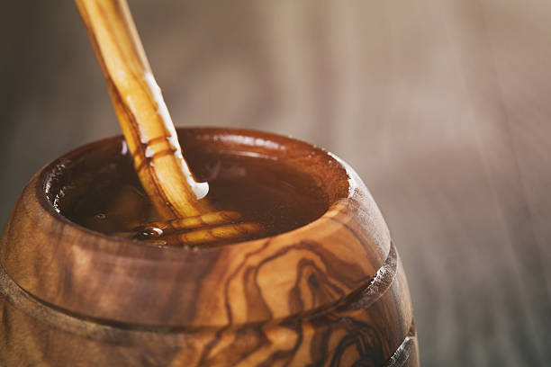 istock honey in olive wood pot with dipper on table 518845328