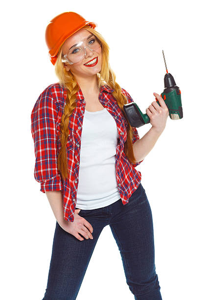 istock Female construction worker in a helmet with a perforator 518845644