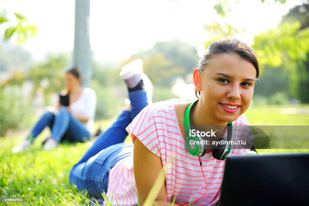 Using a laptop outdoors Smiling girl student laying down in the park. 20-24 Years Stock Photo