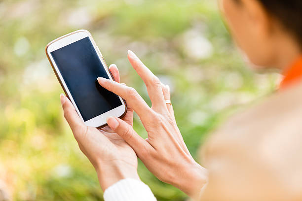istock Woman using smart phone outdoors 518857557