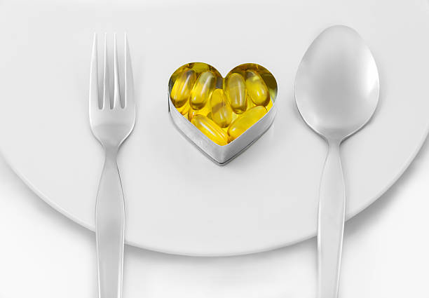 istock Fish oil heart on dish menu 518858491