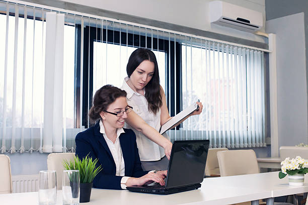 istock two beautiful business women communicate at office 518859510
