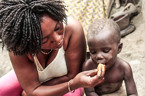 People walking and children playing on the street of a slum in Luanda