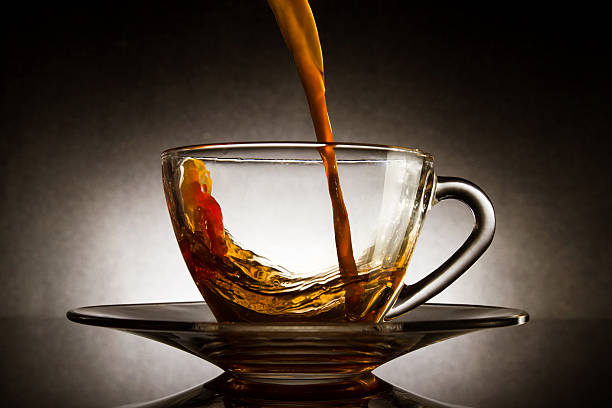 istock Pour coffee into transparent glass cup with dark background. 518861279
