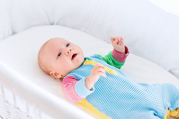 istock Cute baby boy in a white crib   bottle 518868144