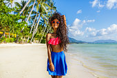 Beautiful black girl in skirt and bra on the beach.