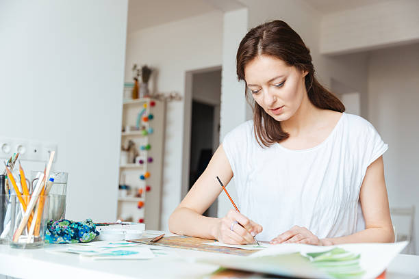istock Beautiful inspired woman painter painting in art studio 518868974