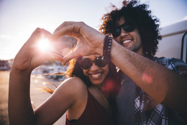 istock Happy young hipster couple making heart shape with hands 518872758