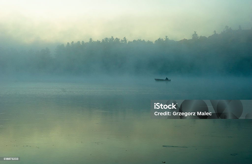 Silhouette of fisherman in early morning mist Dawn Stock Photo