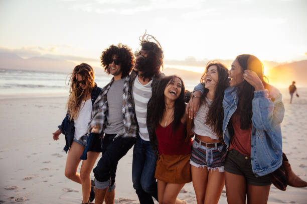 istock Hipster friends embracing joyfully at sunset on seaside 518873572