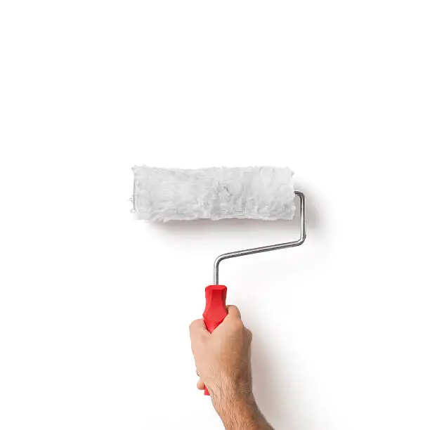 Closeup Of Isolated Painter's Hand Holding Roller Over White Wall