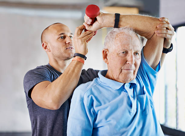 arbeiten auf seinem weg zurück zu einer gesunden selbstparken - senior adult exercising aging process instructor stock-fotos und bilder