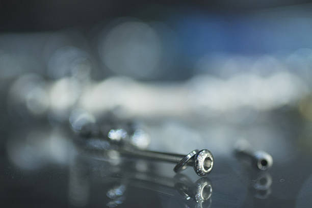 Traumatology orthopedic surgery implant metal screw Closeup macro photo of traumatology orthopedic surgery implant metal screw set against blue out of focus background. tornillo stock pictures, royalty-free photos & images
