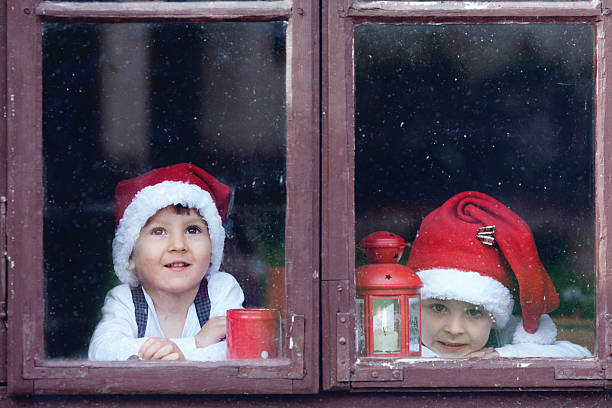istock Two cute boys, looking through a window, waiting for Santa 518875521