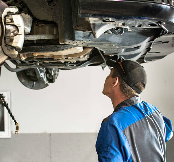 istock Auto Mechanic Under Lifted Vehicle 518877161
