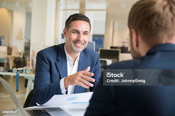 Businessman With Colleague In Meeting Stock Photo - Download Image Now - Businessman, Candid, Discussion