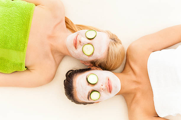 kobiety z plasterki ogórka na oczy i twarz maski - cucumber human eye spa treatment health spa zdjęcia i obrazy z banku zdjęć