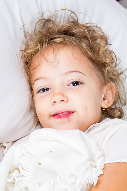 Sick little girl in bed stock photo