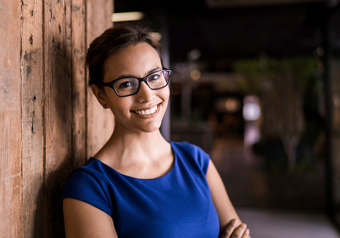 Portrait of confident businesswoman against wooden wall