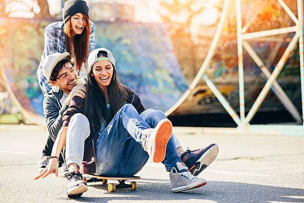 divertimento con skateboard - teenager city life laughing group of people foto e immagini stock