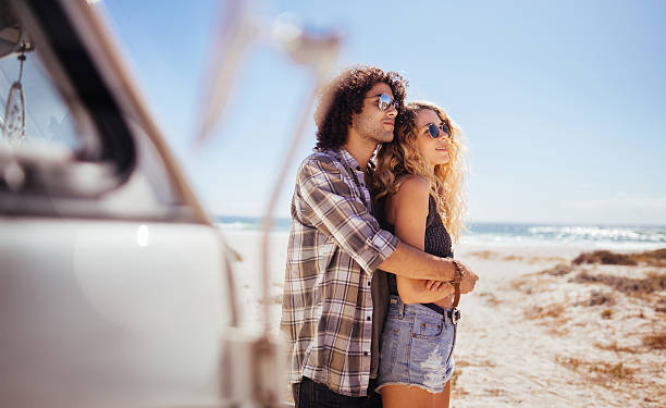 istock Trendy Hipster Couple Hugging in front of a Sandy Beach 518883040