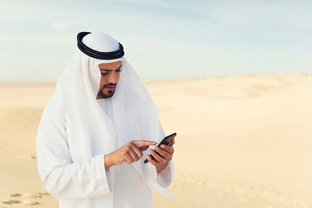 Using mobile phone in the desert stock photo
