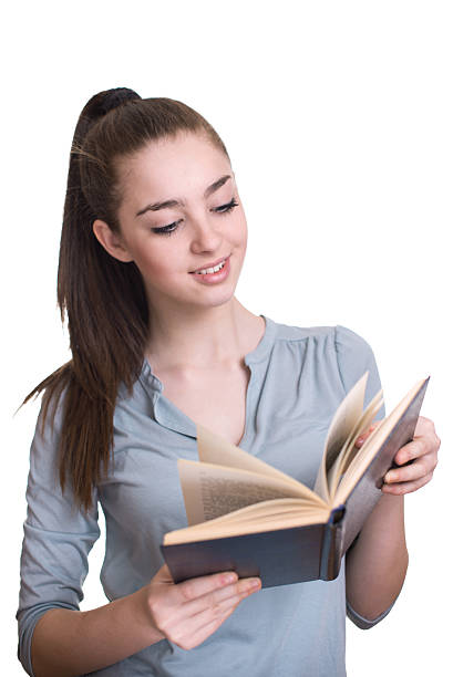 istock Young beautiful girl reading a book and smiling 518884392
