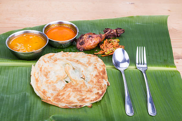 istock Traditional roti prata served on banana leaf with curry dhal. 518885062