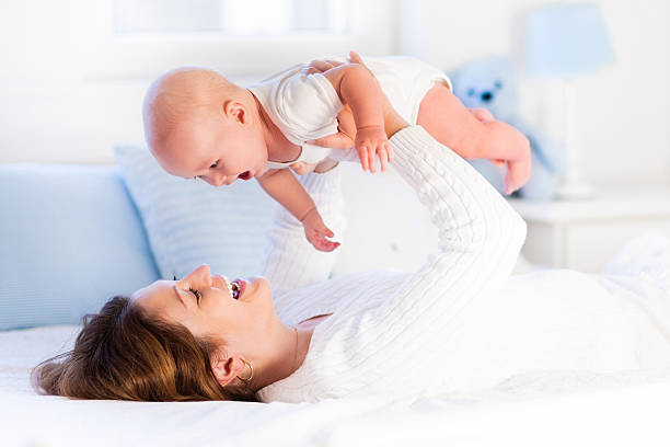 istock Young mother and baby on a white bed 518885924
