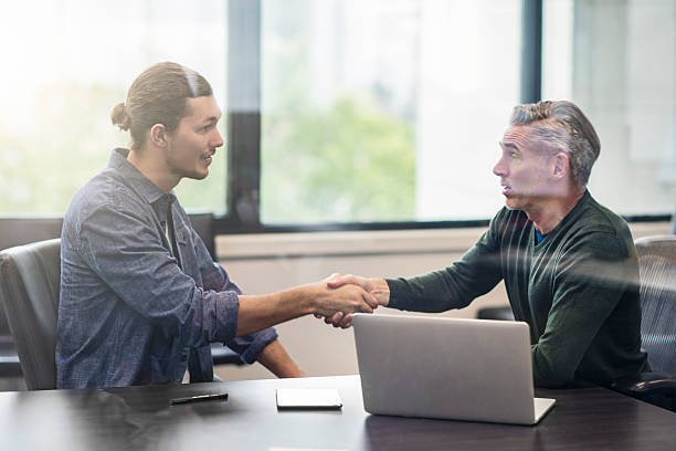 Two business people shaking hands on an interview. Two business people shaking hands after the interview in the office. casual job interview stock pictures, royalty-free photos & images