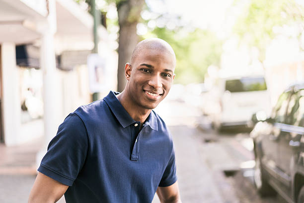 hombre de pie en el exterior tienda confianza - polo shirt african ethnicity men african descent fotografías e imágenes de stock