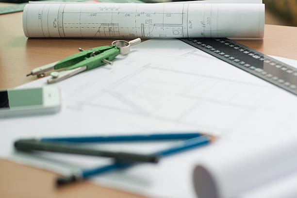 istock Architectural blueprints and blueprint rolls and a drawing instruments 518887220