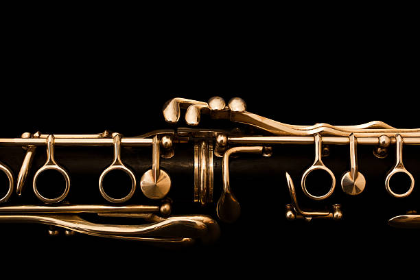 Detail of clarinet on black background Detail of clarinet closeup in golden colors on a black background classical music photos stock pictures, royalty-free photos & images